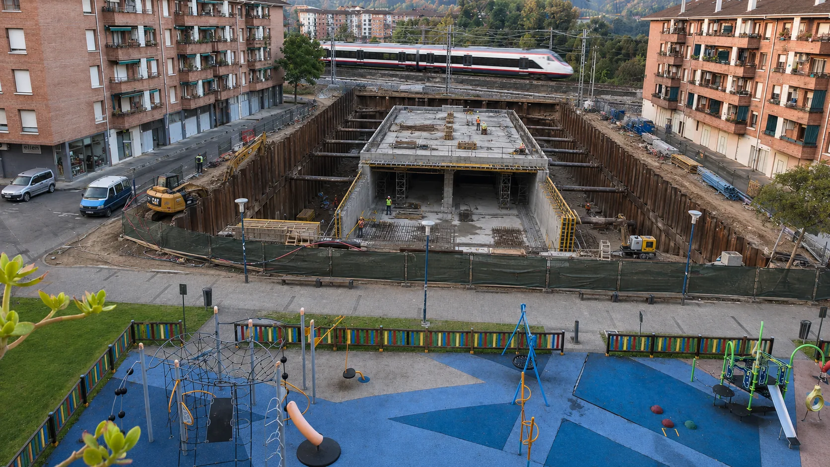 Simulación: excavación del cajón del paso inferior con un tren circulando por encima, maquinaria de obra visible